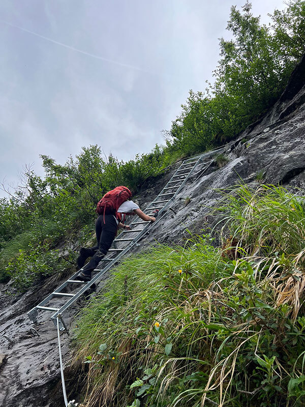 Wanderer klettert eine steile und rutschige Leiter herunter