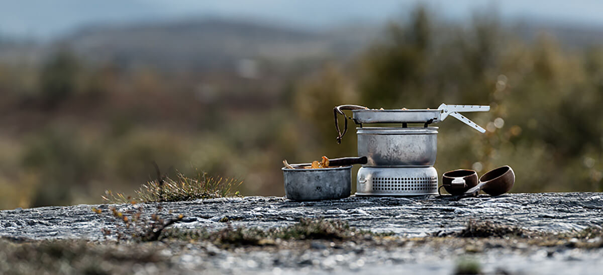 Trangia Kocher auf Felsen in herbstlicher Landschaft