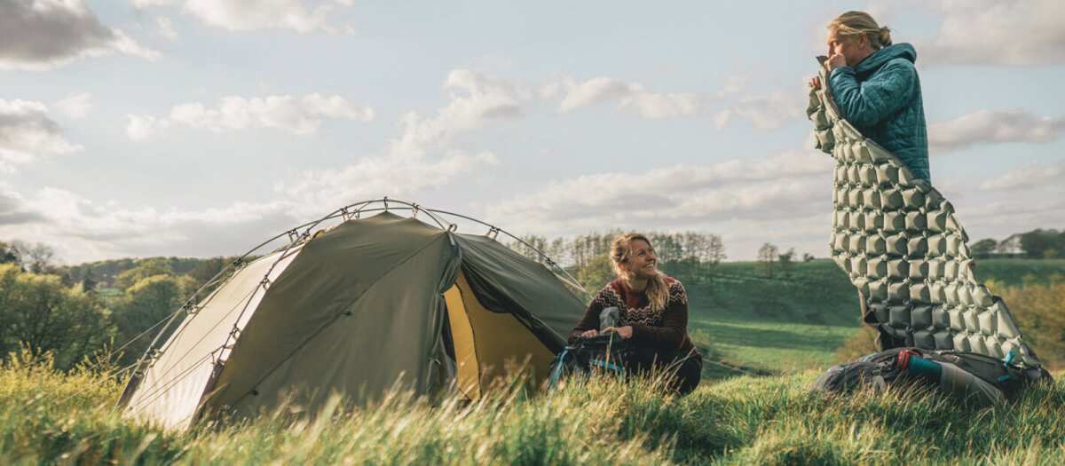 Paar mit Trekkingzelt auf Wiese