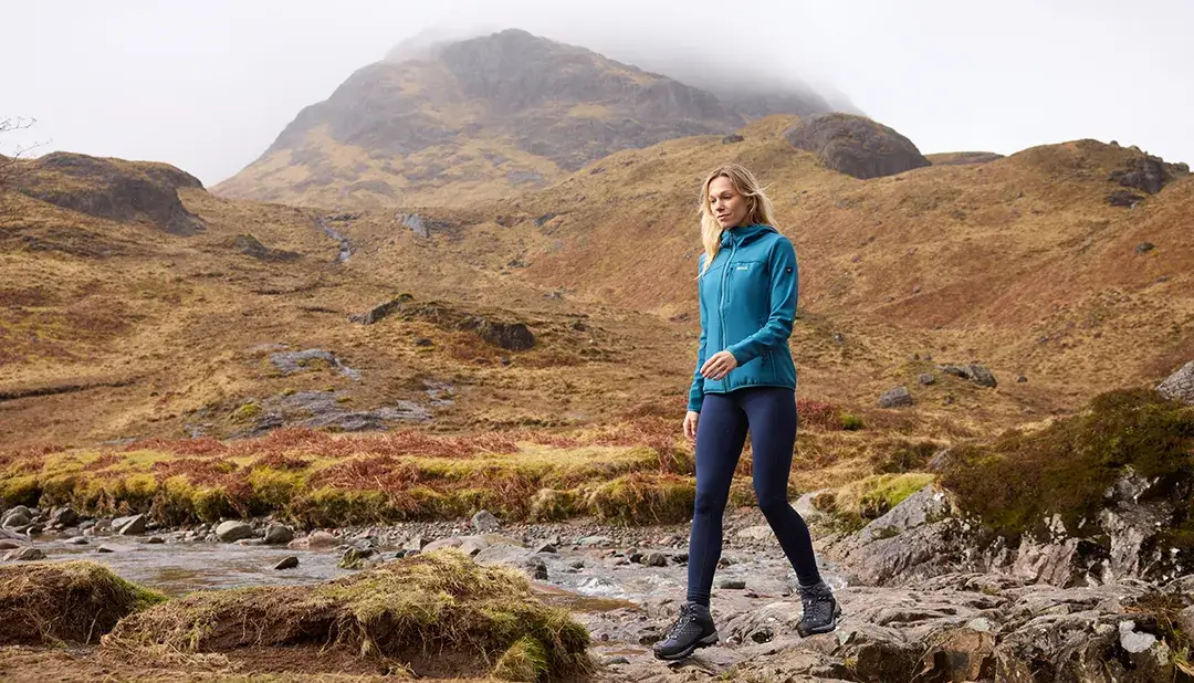 AW25_ACTIVE_JACKETS_WOMENSOSSEK_RWL285_4VK_(1) Frau mit Softshell in bergigem Gelände